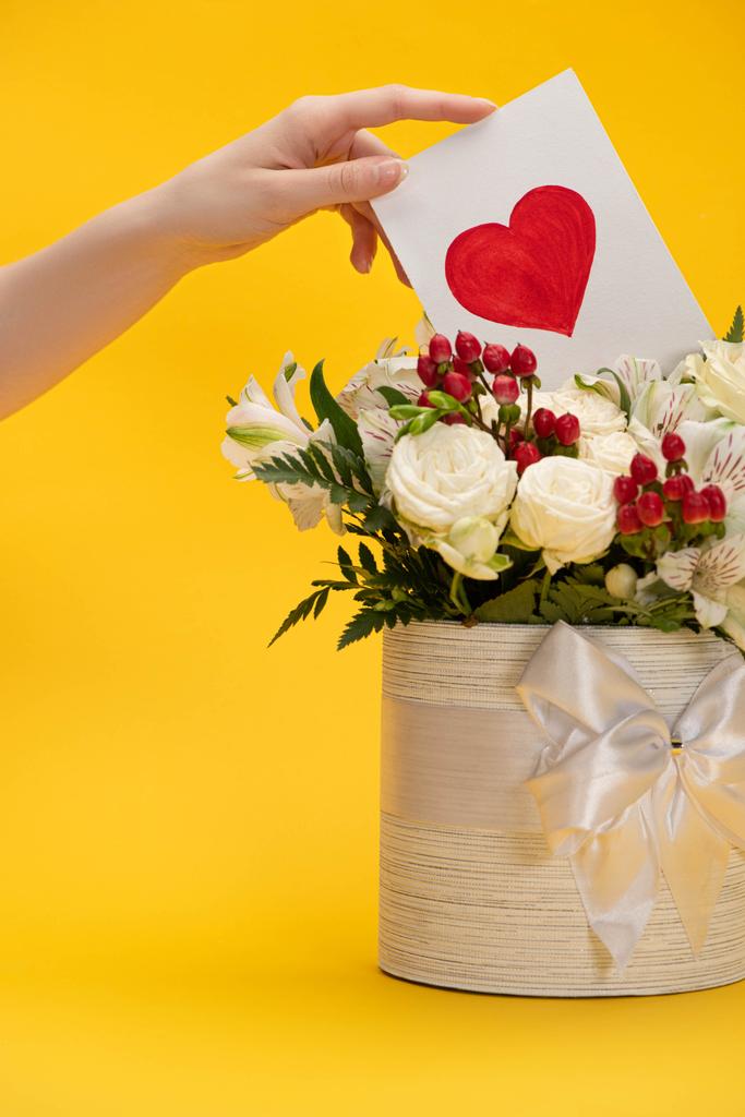 Sevgililer günü kartlarını bahar çiçeği demetine koyan bayramlık hediye kutusunda sarı kurdeleli bir kadın. - Fotoğraf, Görsel