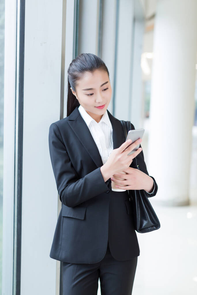 menina bonita vestindo um terno preto, de pé no prédio de escritórios
 - Foto, Imagem
