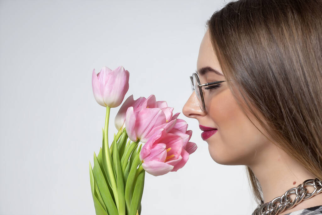 Joven hermosa chica con tulipanes rosados en sus manos
. - Foto, imagen