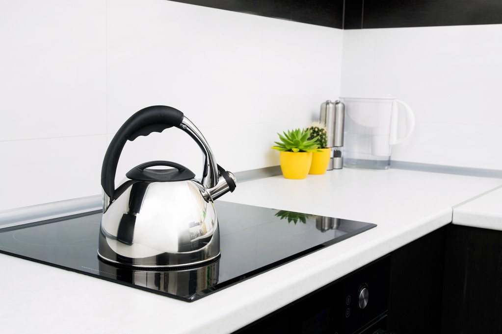 Chaleira de aço na cozinha moderna com fogão de indução
 - Foto, Imagem