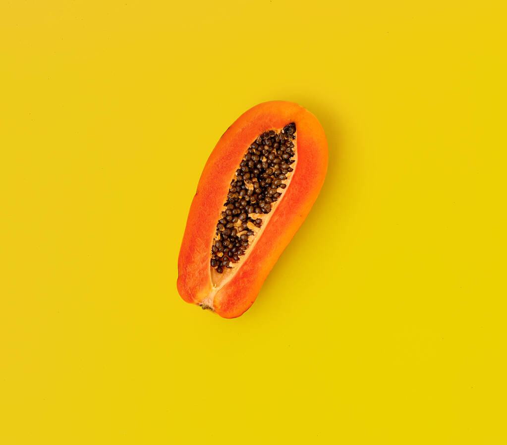 Half fresh ripe papaya on yellow background. - Photo, Image