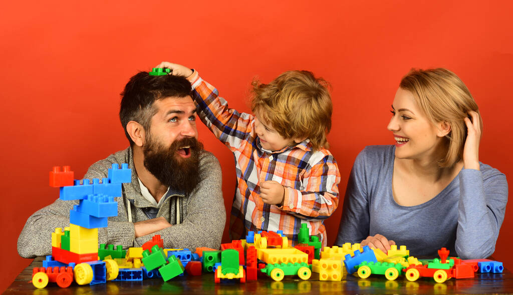 Niño niño junto con la madre y el padre jugando juguetes educativos
. - Foto, Imagen