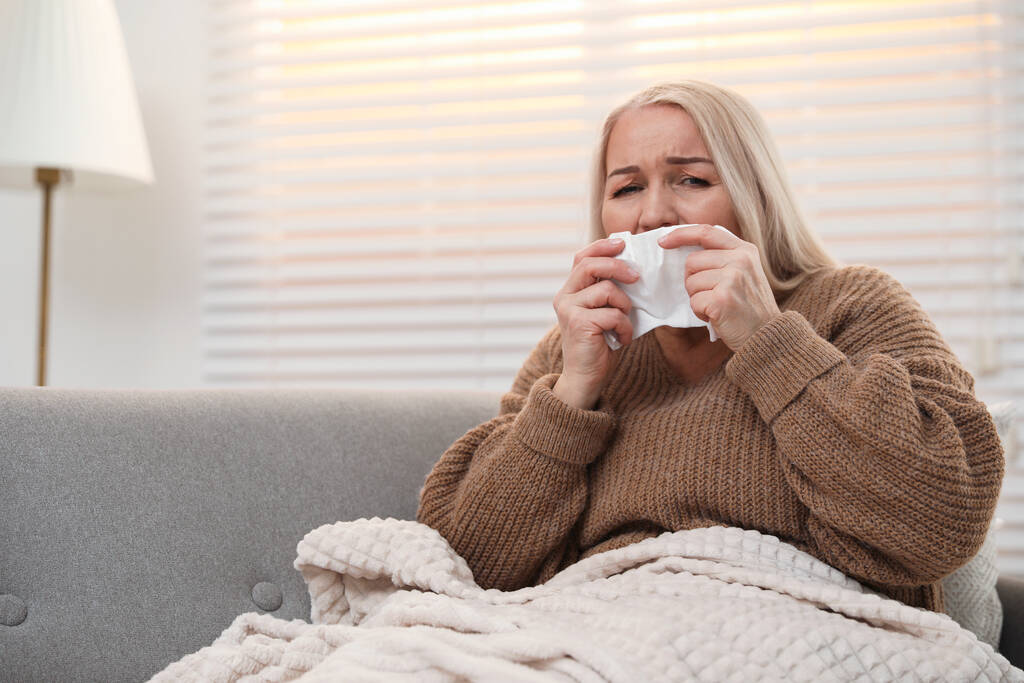 Dojrzała kobieta cierpiąca na zimno w domu. Niebezpieczny wirus - Zdjęcie, obraz