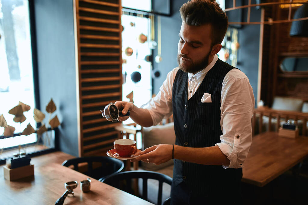 hardworking man in elegant suit concentrated on spilling the grounded coffee - Photo, Image