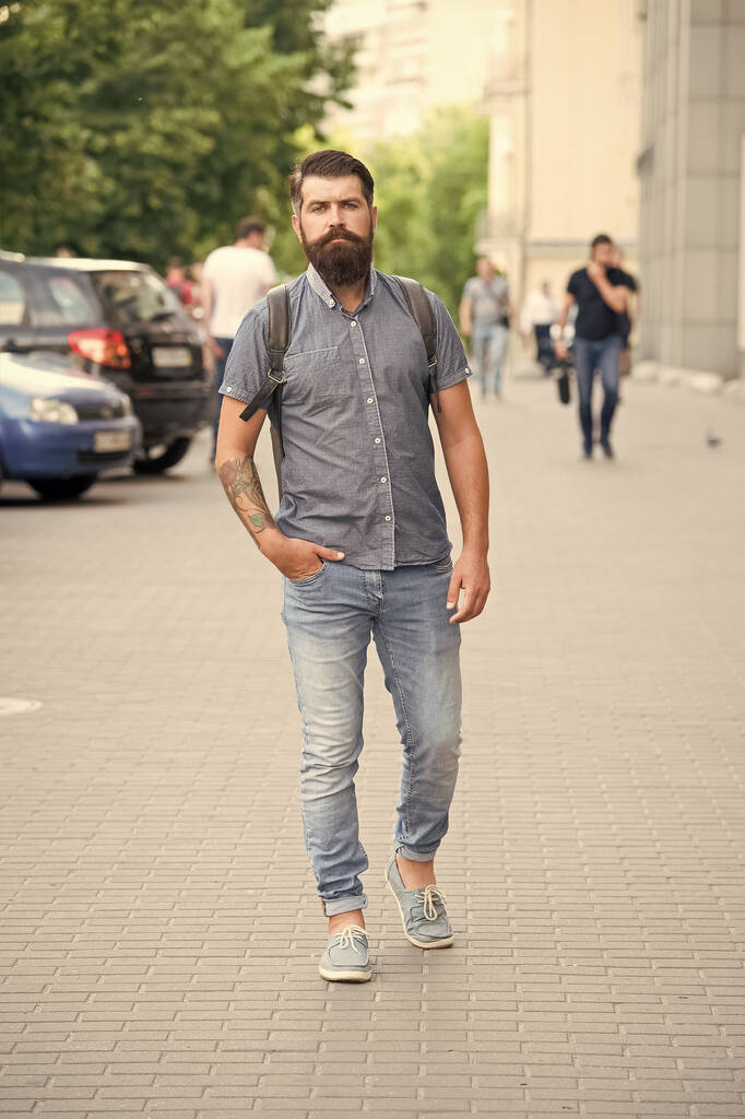 Confident brutal man walk street. Male barber care. brutal hipster with moustache. adventure concept. urban style. Commit to travel. Mature hipster with beard. Bearded man wear backpack - Photo, Image