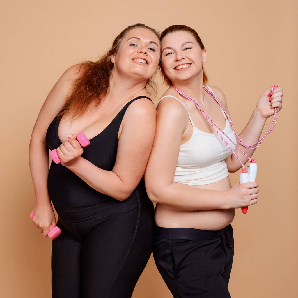 Meninas com excesso de peso em aulas de fitness, posando com halteres e pular corda
 - Foto, Imagem