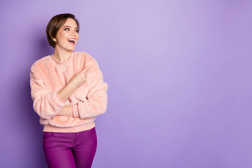Retrato de alegre promotor de chica positiva disfrutar de anuncios promocionales que mira indican presente risa desgaste estilo casual traje borroso aislado sobre fondo de color púrpura
 - Foto, imagen