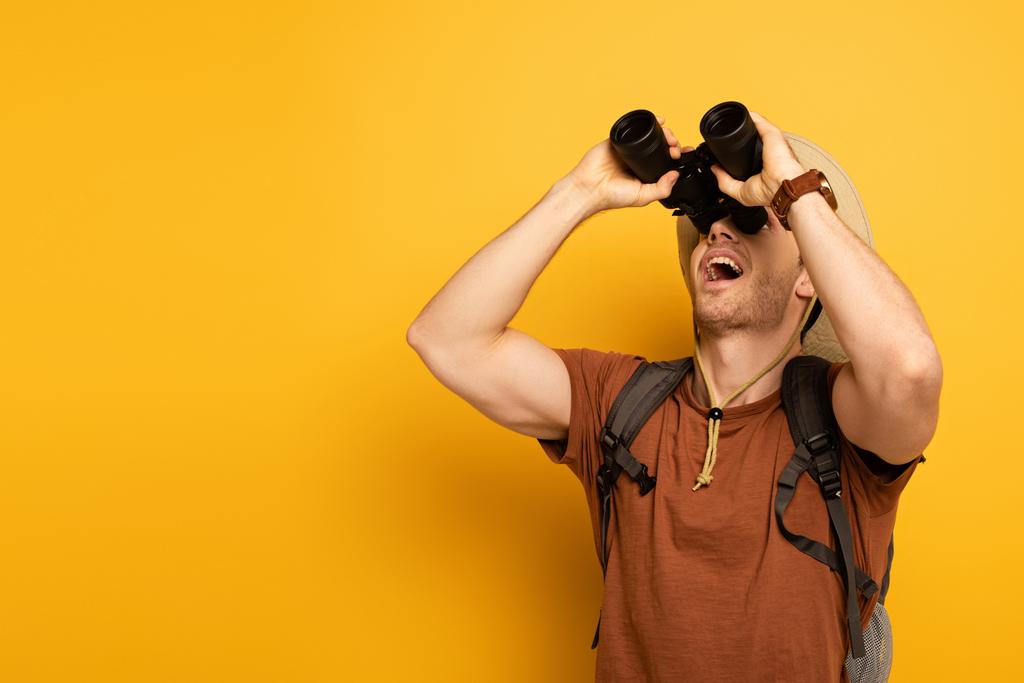 pohledný zamyšlený cestovatel dívající se dalekohledem na žluté - Fotografie, Obrázek