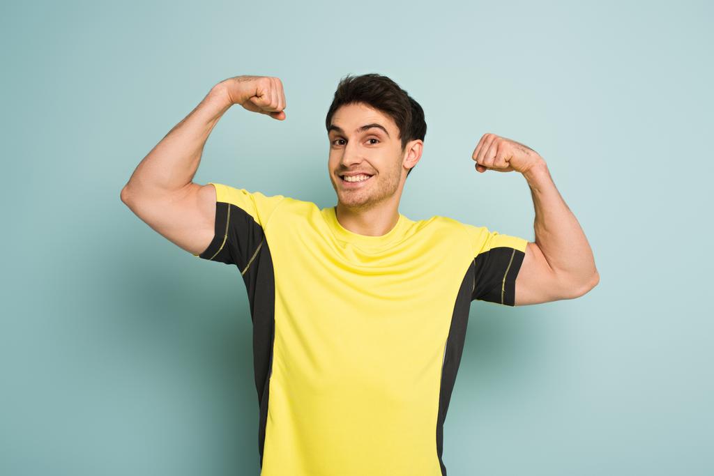 iloinen lihaksikas urheilija keltainen t-paita sininen
 - Valokuva, kuva