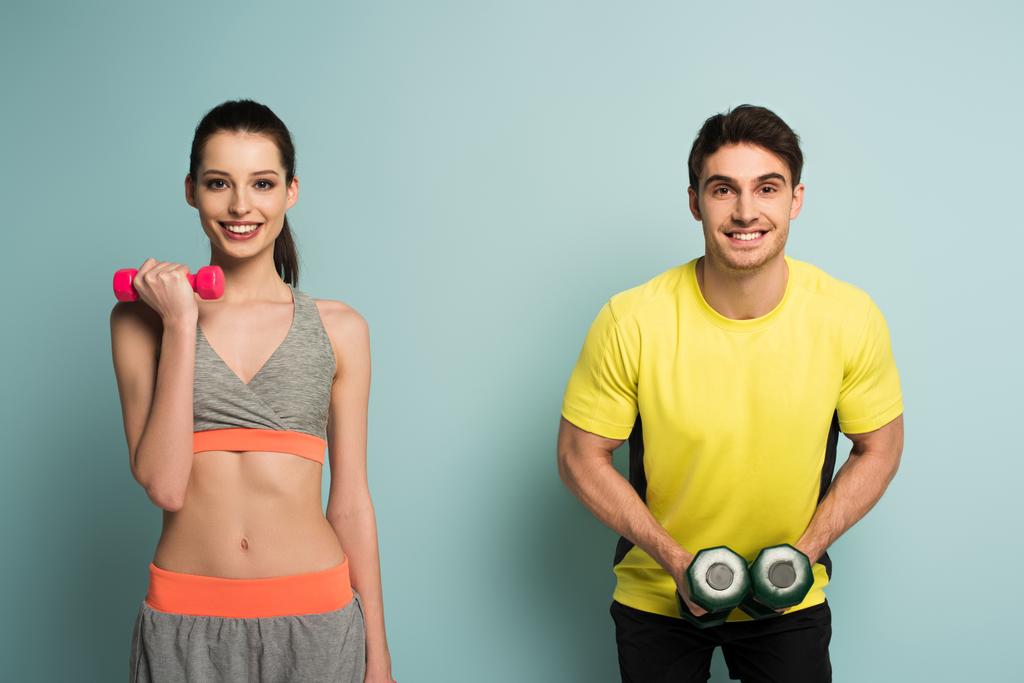 entrenamiento de pareja atlética feliz con pesas en azul
 - Foto, imagen