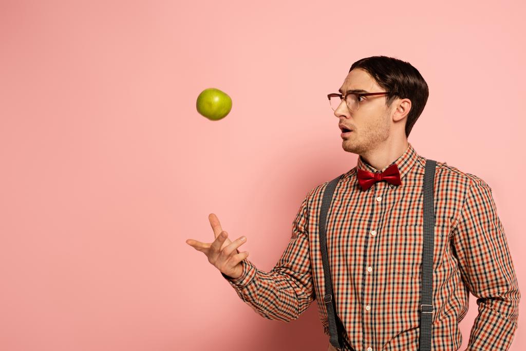 chocado masculino nerd no óculos jogando maçã no rosa
 - Foto, Imagem