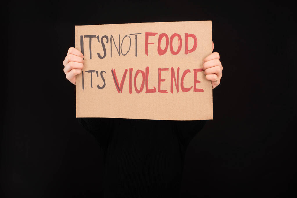 vue partielle d'une femme tenant une pancarte en carton avec sa nourriture non-alimentaire son inscription de violence isolée sur noir
 - Photo, image