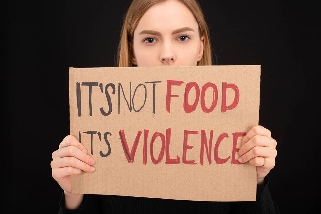 γυναίκα με σκοτεινό πρόσωπο κρατώντας χαρτονένιο σήμα με την όχι τροφή του επιγραφή βίας του που απομονώνονται σε μαύρο - Φωτογραφία, εικόνα