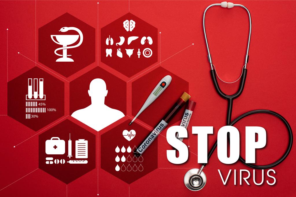 Vista dall'alto di stetoscopio, termometro e provette con campioni di sangue e lettere del virus stop su sfondo rosso
 - Foto, immagini