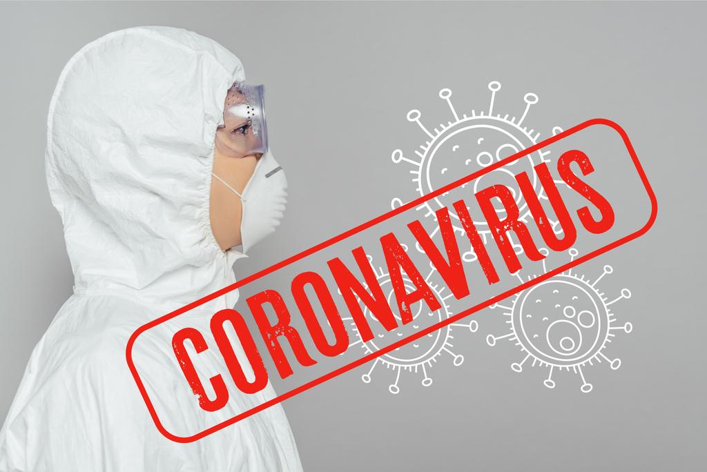 zijaanzicht van aziatische epidemioloog in hazmat pak en masker geïsoleerd op grijze, coronavirus illustratie  - Foto, afbeelding