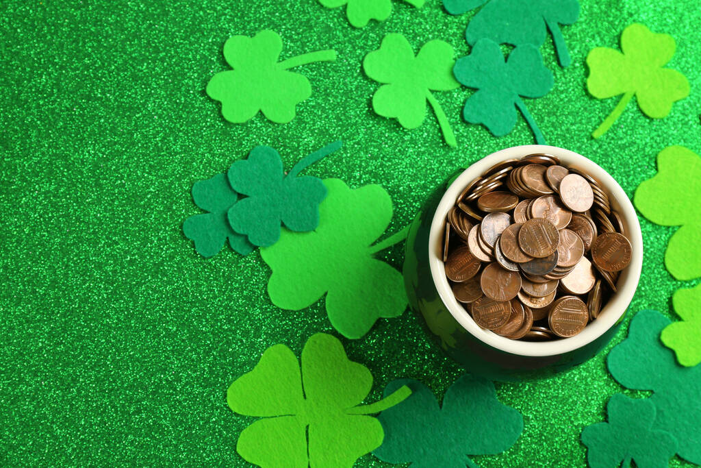Topf mit Goldmünzen und Kleeblättern auf grünem Hintergrund, flach gelegt. St. Patrick 's Day Feier - Foto, Bild