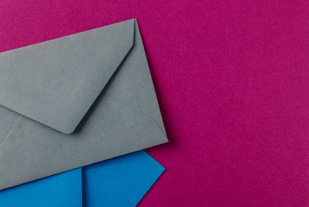 Красочные конверты на фиолетовом фоне. Почтовые конверты на столе
. - Фото, изображение
