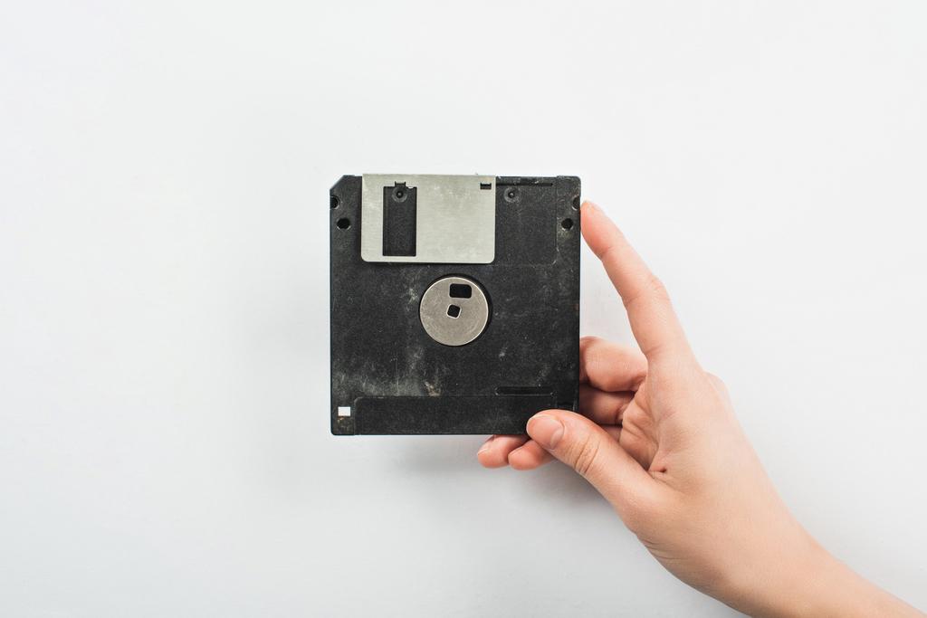 partial view of man holding black diskette on white background - Photo, Image