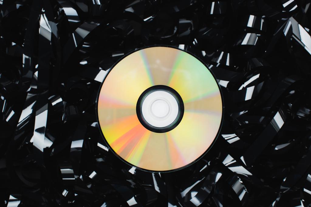Siyah film şeridi üzerindeki CD diskin üst görünümü - Fotoğraf, Görsel