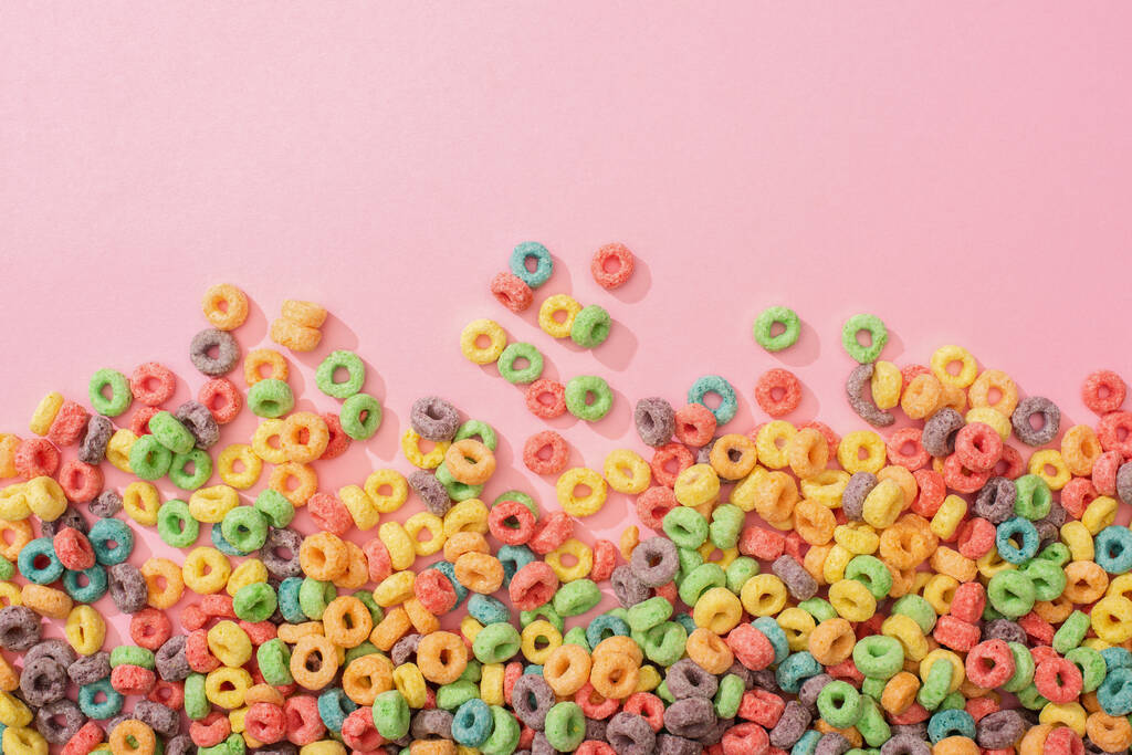 vista superior de cereales de desayuno multicolores brillantes sobre fondo rosa
 - Foto, imagen
