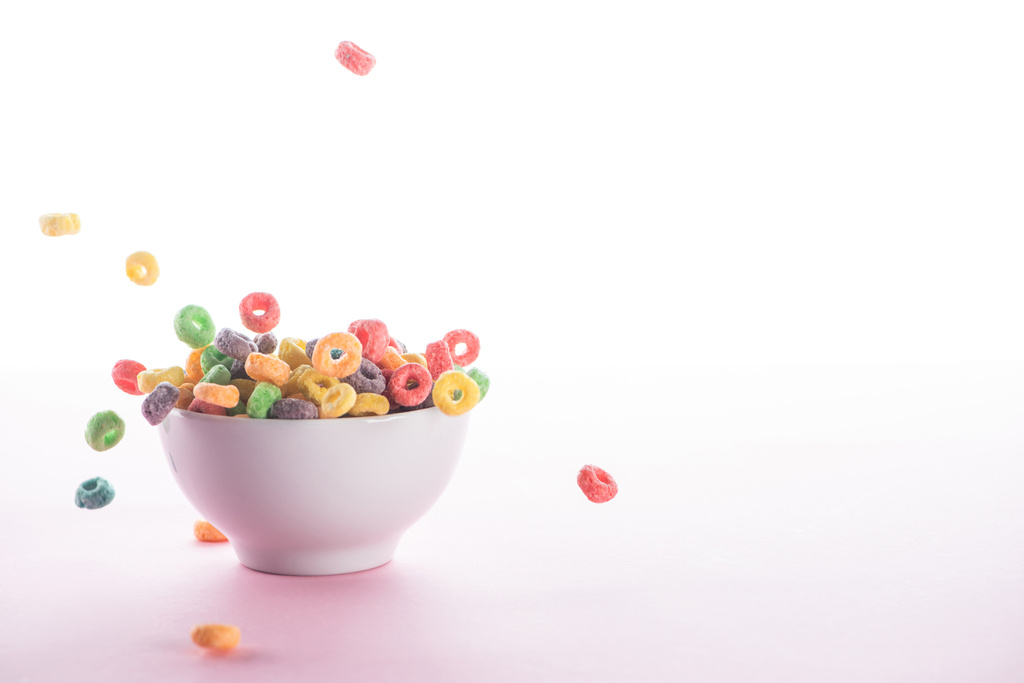 brilhante cereal café da manhã multicolorido caindo em tigela no fundo branco
 - Foto, Imagem