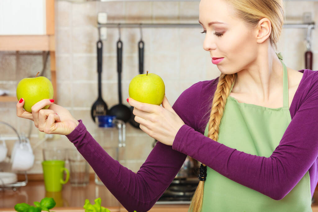 Молодая женщина с длинными волосами держит два больших зеленых яблочных фрукта. Здоровое питание, вегетарианская еда, диета и концепция людей. - Фото, изображение