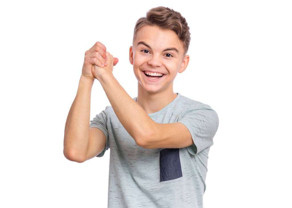 Portrét šťastného dospívajícího chlapce ukazujícího vítězné gesto. Úspěšné a oslavující vítězství, triumfální dítě dělá výhru znamení. Hezký kavkazský mladý teenager, izolovaný na bílém pozadí. - Fotografie, Obrázek