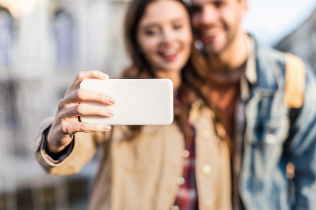 Ausgeschnittene Ansicht von Paar, das Selfie mit Smartphone macht  - Foto, Bild
