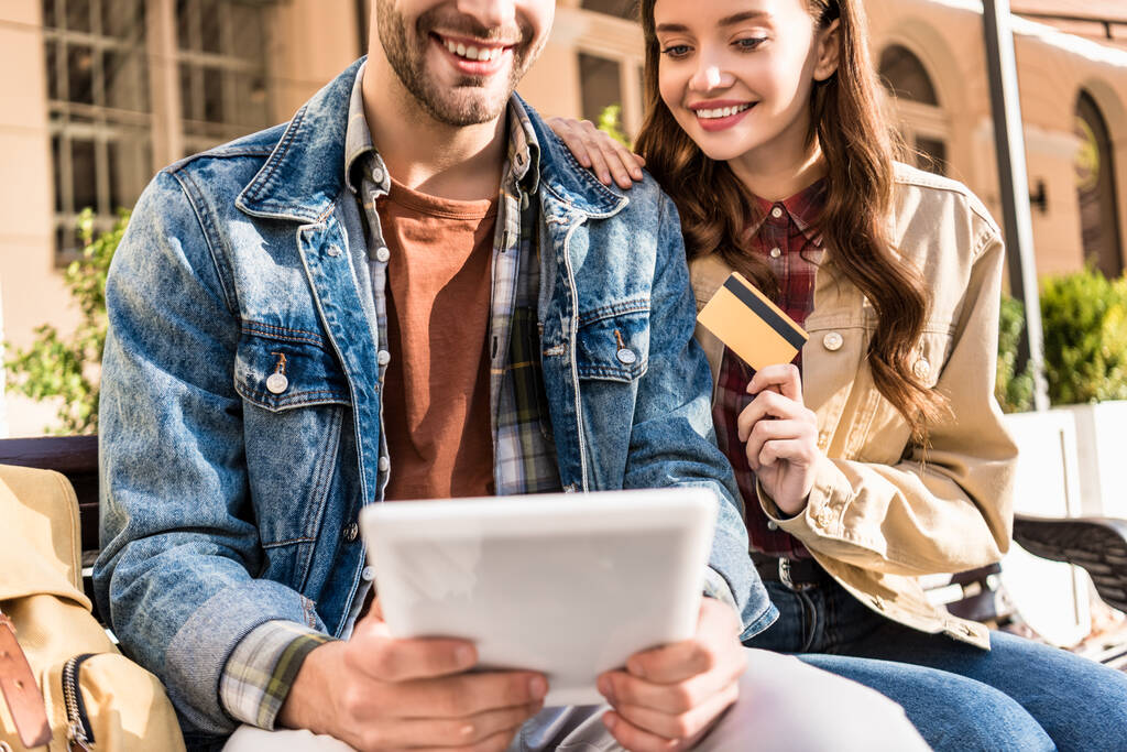 Oříznutý pohled na pár usmívající se a držící kreditní kartu a digitální tablet  - Fotografie, Obrázek