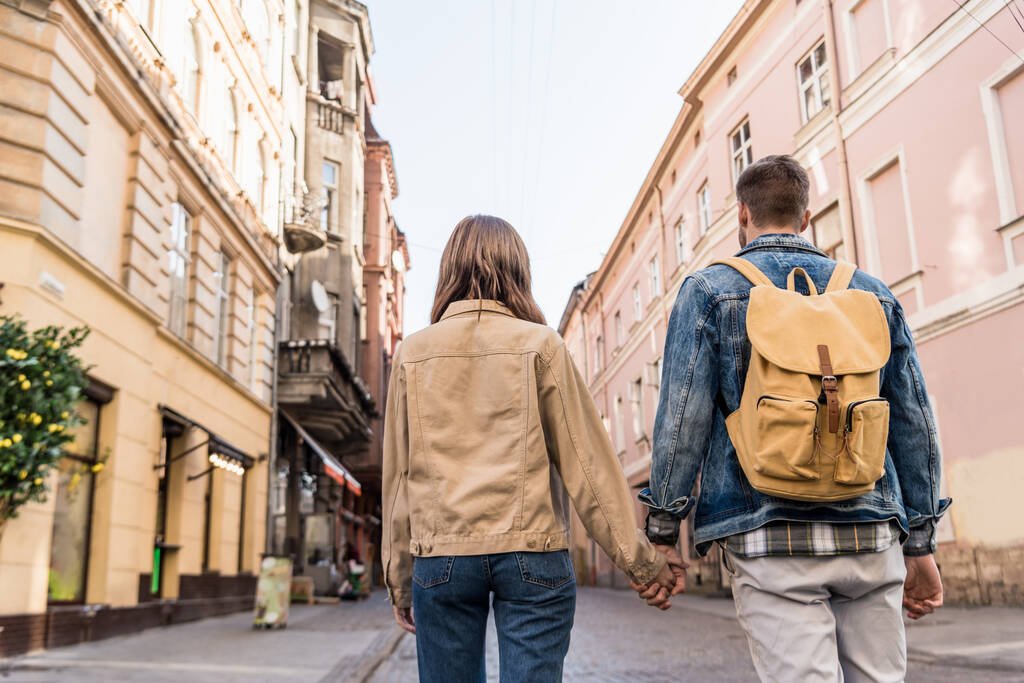 Widok pary trzymającej się za ręce z plecakiem w mieście - Zdjęcie, obraz