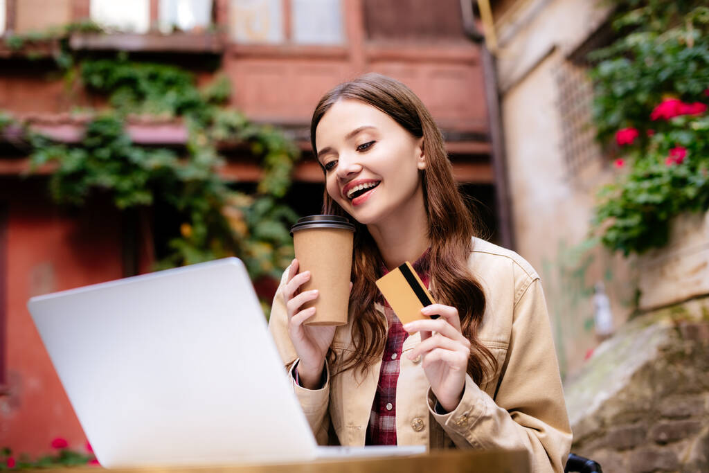 Вибірковий фокус жінки з кредитною карткою за допомогою ноутбука в кафе
  - Фото, зображення