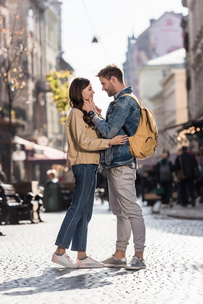 Fidanzato e fidanzata che si guardano sorridendo e abbracciandosi in città in Europa
 - Foto, immagini