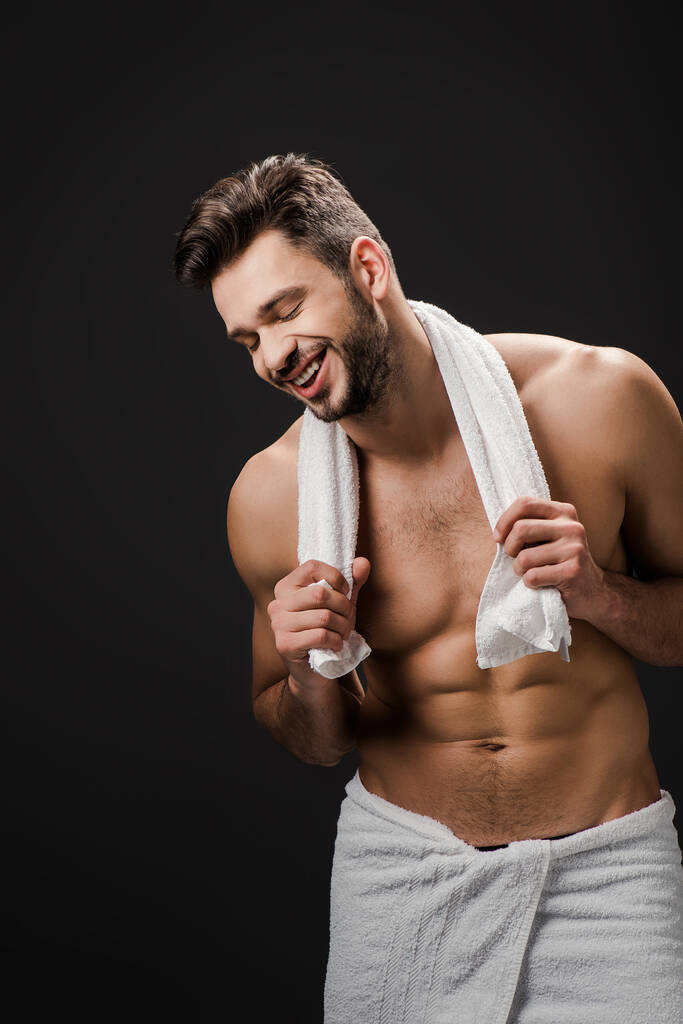 handsome laughing man with towel isolated on black - Photo, Image