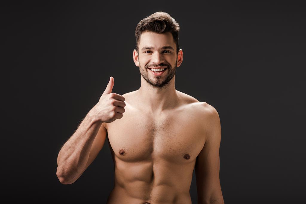 cheerful sexy naked man showing thumb up isolated on black - Photo, Image