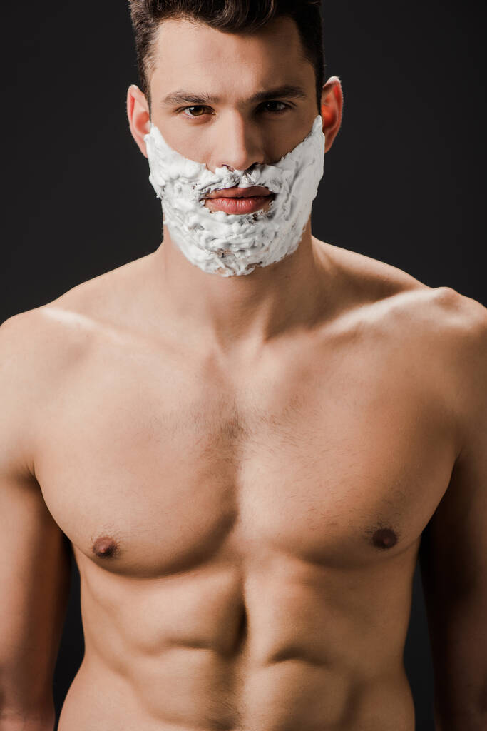 sexy naked man with shaving foam on face isolated on black - Photo, Image