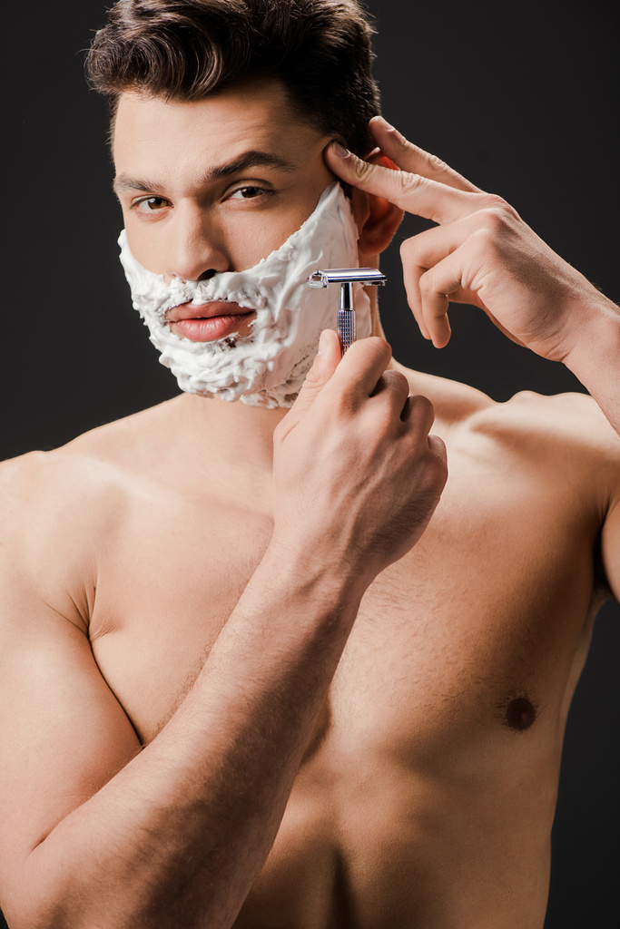 σέξι γυμνό γενειοφόρος άνδρας ξυρίσματος πρόσωπο με ξυράφι απομονώνονται σε μαύρο - Φωτογραφία, εικόνα