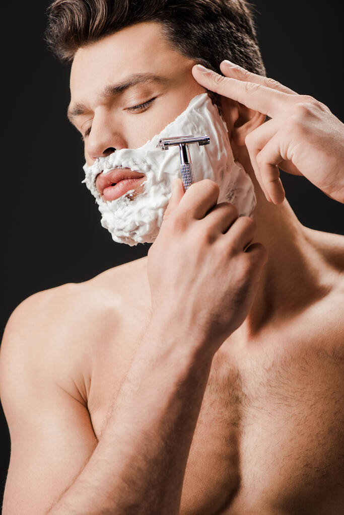sexy nackter Mann rasiert Gesicht mit Rasiermesser isoliert auf schwarz - Foto, Bild