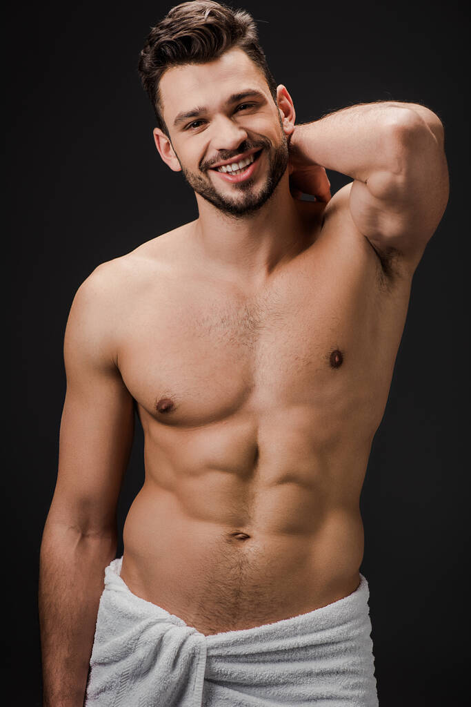cheerful sexy muscular man in towel isolated on black - Photo, Image