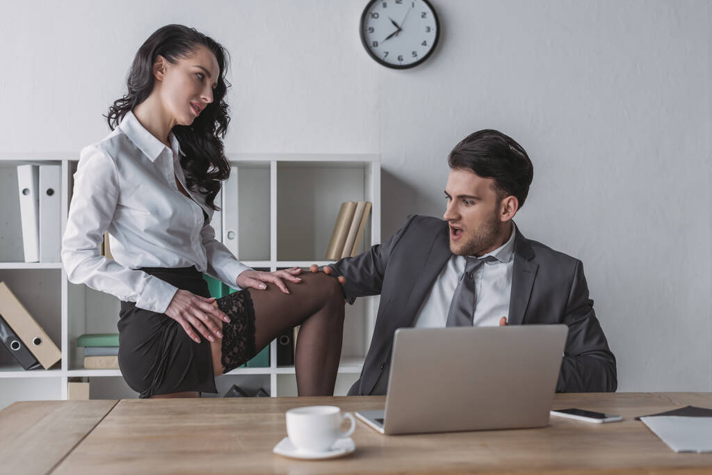 aufgeregter Geschäftsmann berührt Bein von sexy Sekretärin verführt ihn im Büro - Foto, Bild