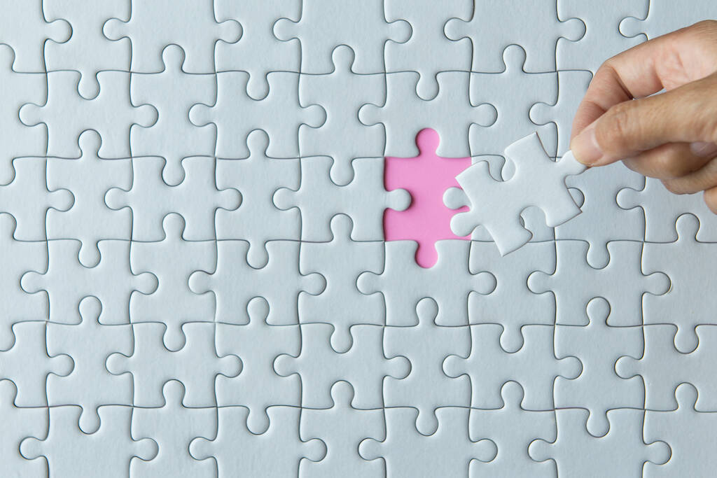 Puzzleteile in Frauenhänden, Puzzle weiße Farbe, Puzzleteile Gitter, Erfolg Mosaik-Lösungsvorlage, Horizontal auf rosa Hintergrund Kopierraum für Text, Draufsicht - Foto, Bild