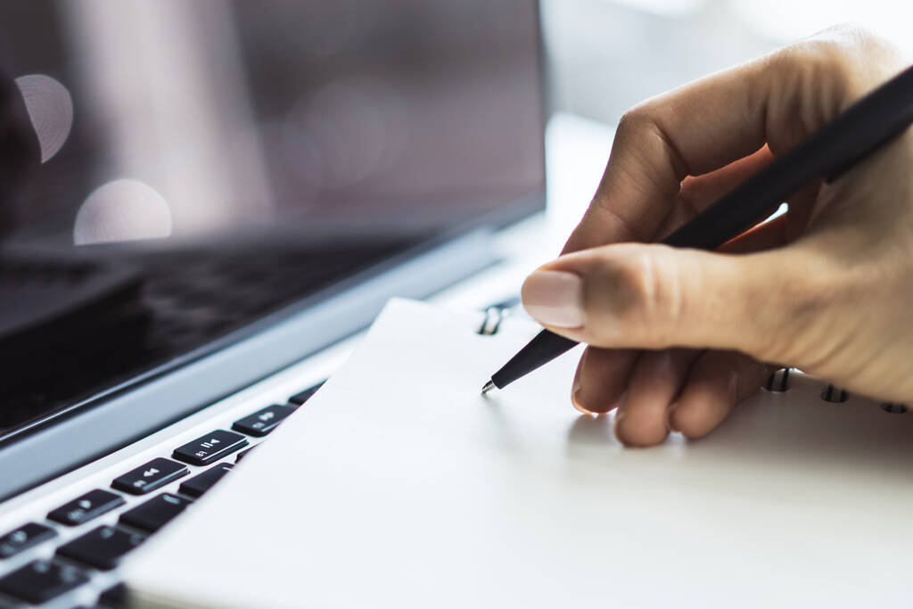 Žena píše s perem v notebooku na klávesnici notebooku ve slunné kanceláři, obchodní a vzdělávací koncept. Zavřít - Fotografie, Obrázek