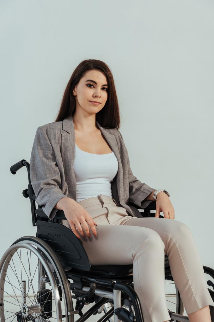 Інвалідність жінка дивиться на камеру на інвалідному візку ізольовано на білому
 - Фото, зображення