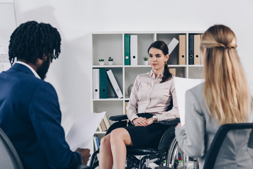 Enfoque selectivo de los reclutadores multiétnicos que realizan una entrevista de trabajo con un empleado discapacitado en el cargo
 - Foto, imagen