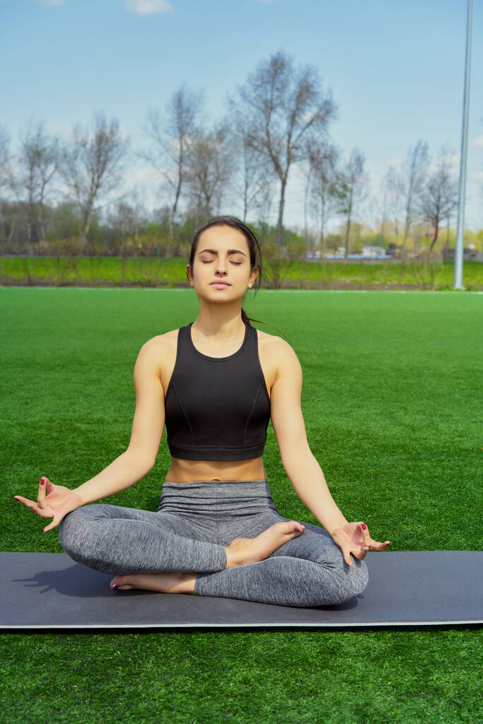 Jeune femme faisant des exercices de yoga en plein air
 - Photo, image