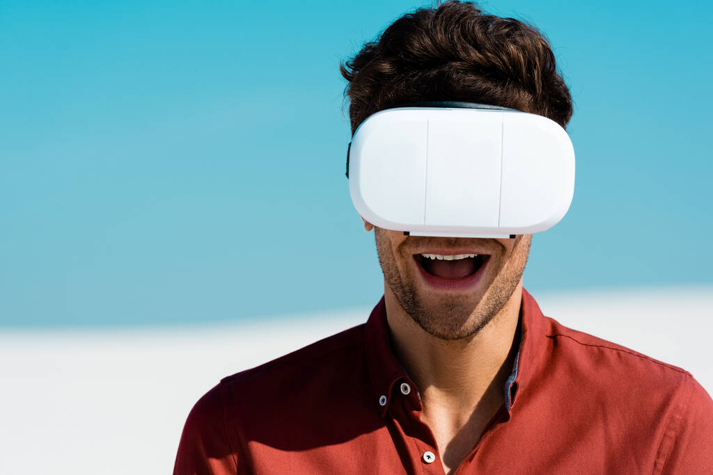 ενθουσιασμένος άνθρωπος στην παραλία σε VR headset κατά καθαρό γαλάζιο ουρανό - Φωτογραφία, εικόνα