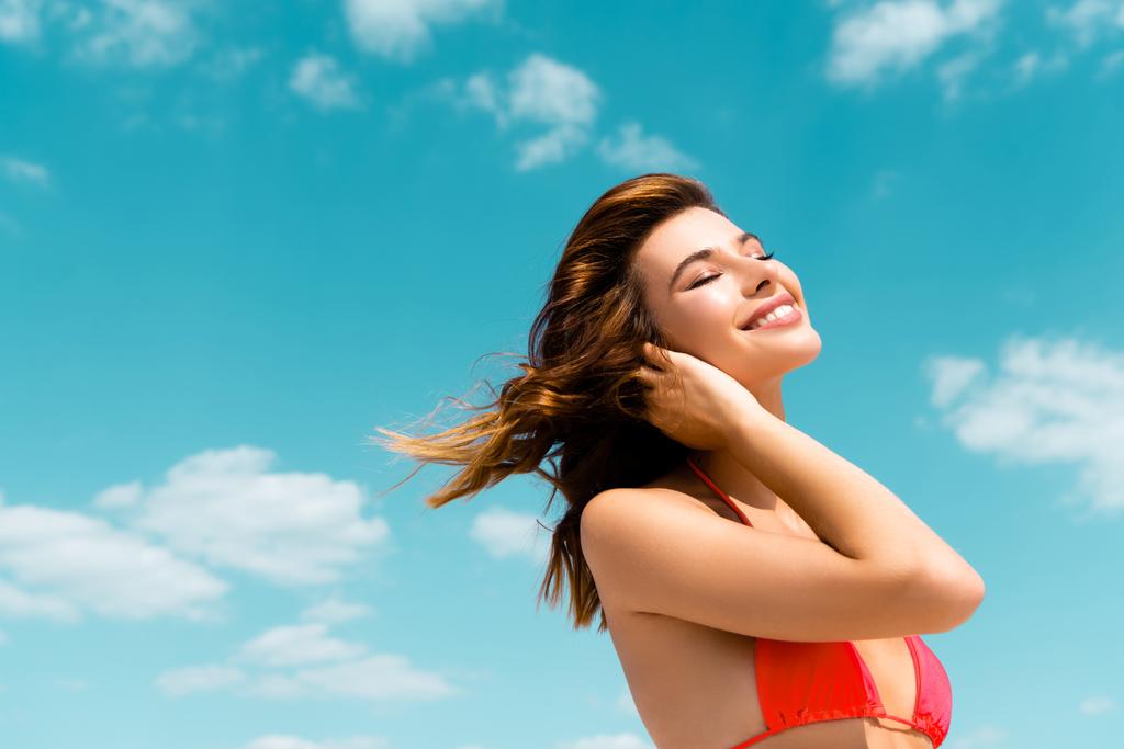gelukkig mooi sexy meisje in badpak op blauwe hemel met wolken achtergrond - Foto, afbeelding