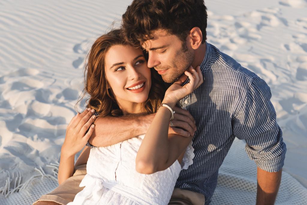 Lächelndes junges Paar umarmt sich am Strand - Foto, Bild