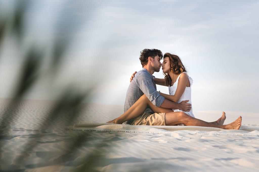 selettiva messa a fuoco di appassionato giovane coppia baci su coperta sulla spiaggia
 - Foto, immagini