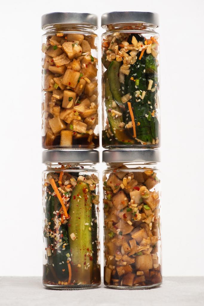 okurka a daikon ředkvička kimchi ve skleněných nádobách izolovaných na bílé - Fotografie, Obrázek
