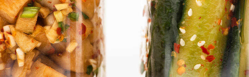 panorámás lövés uborka és daikon retek kimchi üvegben elszigetelt fehér - Fotó, kép